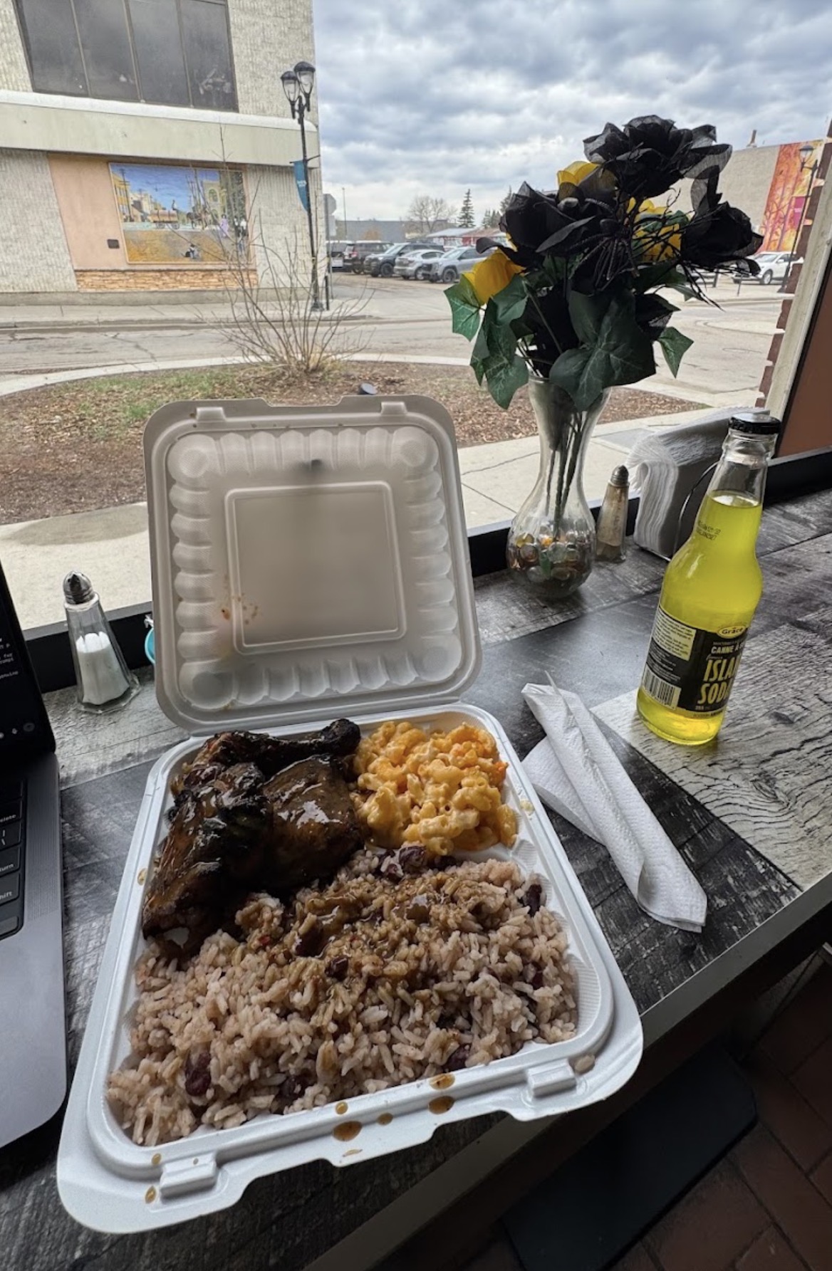 Jerk chicken with rice and peas, mac and cheese, and an island soda